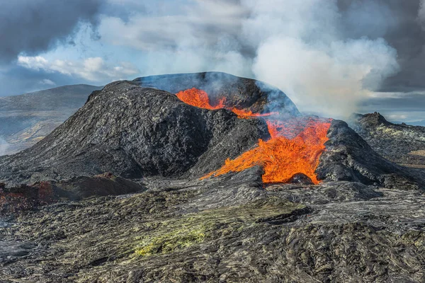 在冰岛喷出熔岩泉的火山 阳光灿烂的日子里 活火山的景象 火山喷发时熔岩流 火山口周围的黑暗岩石 火山火山口的蒸汽 — 图库照片