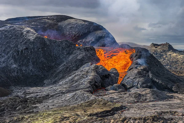 从火山升起的蒸汽 岩浆从火山口流出来 炽热的红色液体岩浆从火山中喷涌而出 冰岛雷克雅未斯半岛的火山景观 冷却的岩浆岩 — 图库照片
