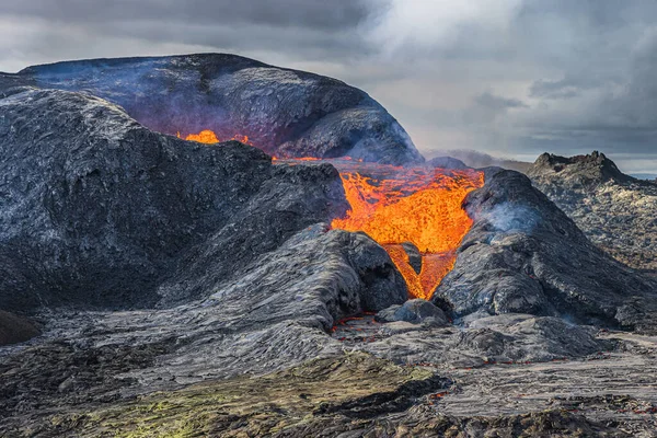 火山火山口的熔岩流得更强 位于地球公园的雷克雅未斯半岛的冰岛景观 在火山口上方喷出更多的烟雾和蒸汽 环绕着火山口的黑暗岩浆 — 图库照片