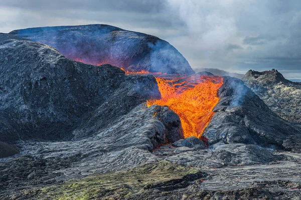 火山火山口的熔岩流得更强 位于地球公园的雷克雅未斯半岛的冰岛景观 从喷出的熔岩开始喷发 火山口上空冒出浓烟和蒸汽 火山口周围的黑暗岩浆 — 图库照片