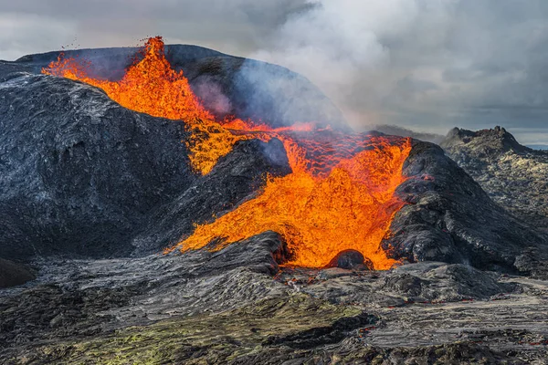 从雷克雅未斯半岛火山喷出熔岩 冰岛的火山景观 喷出的熔岩与蒸汽流过火山口的边缘 火山口周围的黑暗岩浆 多云的天空 — 图库照片