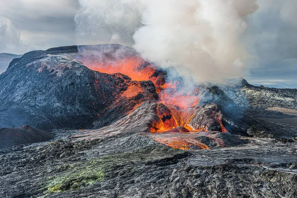 火山火山口上空冒出浓烟和浓烟 炽热的红色熔岩从一个活跃的火山口流出来 位于雷克雅未斯半岛的冰岛景观 白天和阳光下的天空多云 — 图库照片