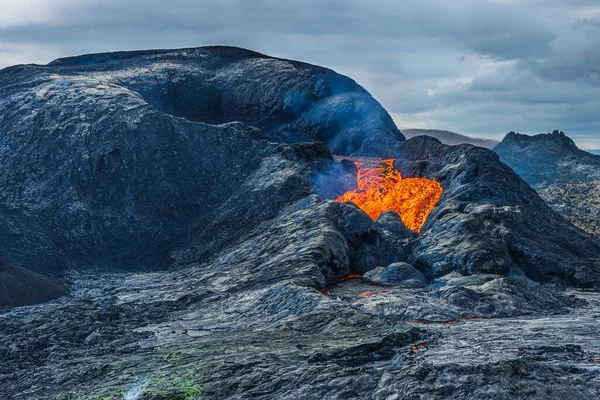 冰岛的火山口 雷克雅内斯半岛活火山 黄昏时分 天空阴云密布 熔岩从火山口流出 火山口周围有较暗的岩浆 — 图库照片