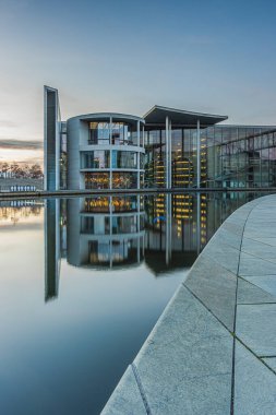 Berlin 'in merkezine nehir yatağı kurun. Paul Lbe 'nin evindeki hükümet dairesi. Günbatımında Spree nehrinin yansımasıyla aydınlanan hükümet binası. Mavi gökyüzünde bazı bulutlar