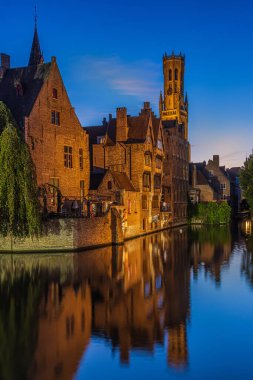 Günbatımından sonra Belçika 'nın Bruges kenti. Hanseatic şehrindeki tespih kanalı. Su yüzeyinde tarihi binaların yansımaları. Yazın aydınlanmış eski tüccar evleri