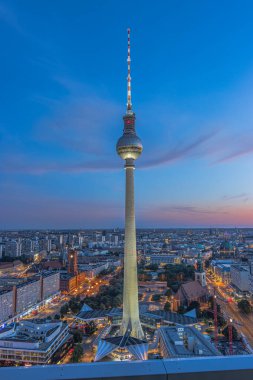 Almanya 'nın başkentinde televizyon kulesi. Berlin 'in merkezindeki Alexanderplatz' daki gökdelenden bir görüntü. Akşam mavi saatte şehrin simgesi. Aydınlatılmış cadde ve yüksek binalar