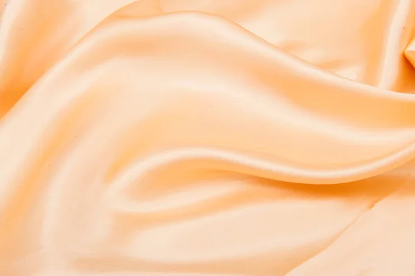 background with folds of peach-beige silk