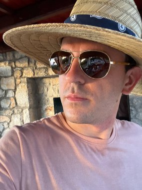 Portrait of a man in sunglasses and a straw hat. High quality photo