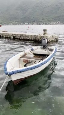 Fishing motor boat rocking on the waves near the pier. High quality 4k footage