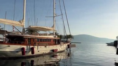 Sailing yacht stands near the shore overlooking the mountains. High quality 4k footage
