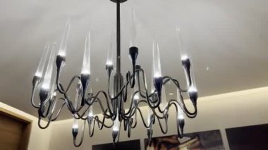 Modern chandelier with candle lamps hanging from the ceiling. High quality 4k footage