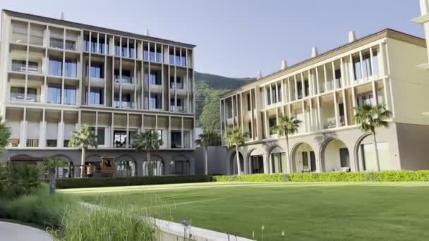 Grön Gräsmatta Framför Ett Modernt Hotell Med Terrasser Och Välvda — Stockvideo