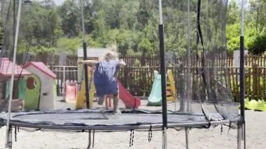 Çocuk parkında trambolinde zıplayan küçük bir kız. Yüksek kalite 4k görüntü