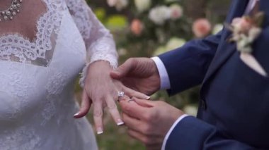 Groom puts the ring on the bride finger. Cropped. High quality FullHD footage