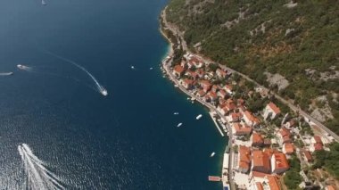 Kotor Körfezi boyunca uzanan yatlar antik Perast kıyılarını geçer. Drone. Yüksek kalite 4k görüntü