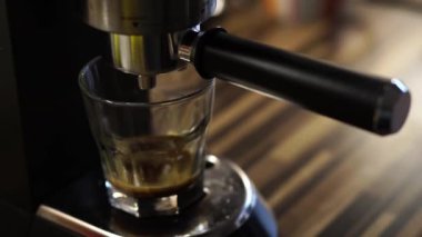 Coffee machine prepares coffee by dripping into a glass. High quality 4k footage