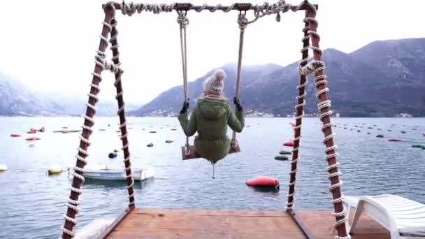 Girl Swings Swing Pier Looks Mountains High Quality Footage — Vídeo de stock