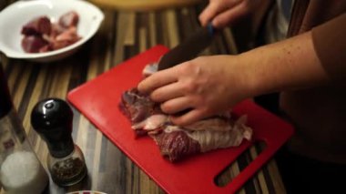 Cook cuts raw meat into pieces on a cutting board on the table. High quality 4k footage