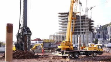 Construction workers watch a drilling rig drilling into the ground. High quality 4k footage