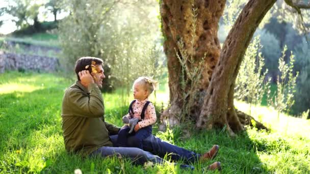 Tata Mała Dziewczynka Siedzą Trawniku Ozdabiają Głowy Gałęziami Liści Wysokiej — Wideo stockowe