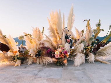 Composition of flowers and dried flowers stands on a tile. High quality photo