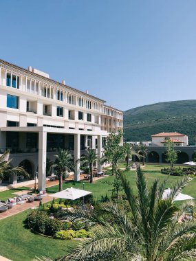 Modern hotel with gazebos and green palm trees in the garden. High quality photo