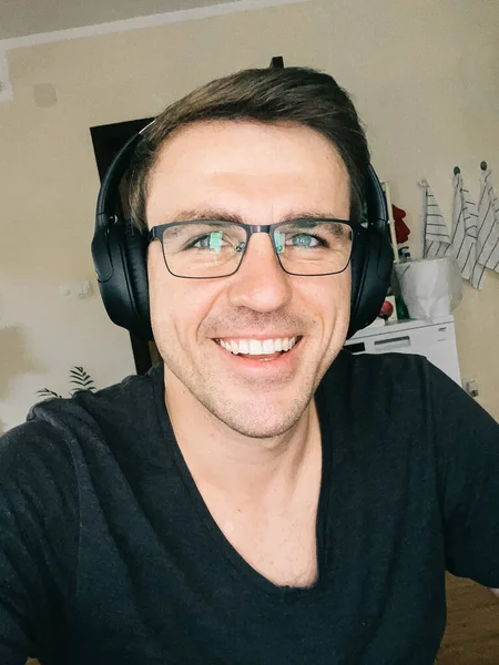 Smiling man wearing glasses and wireless headphones. High quality photo