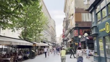 Pedestrians walk along the old street of the town. High quality 4k footage