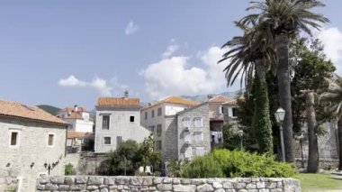Green trees in the garden near ancient stone houses. High quality 4k footage
