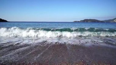 Sea surf with white foam rolls on a gravel beach. High quality FullHD footage