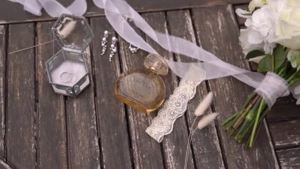 结婚戒指 花边吊袜带 珠宝和香水都在桌上 Terre Lumiere Leau Loccitane 优质Fullhd影片 — 图库视频影像