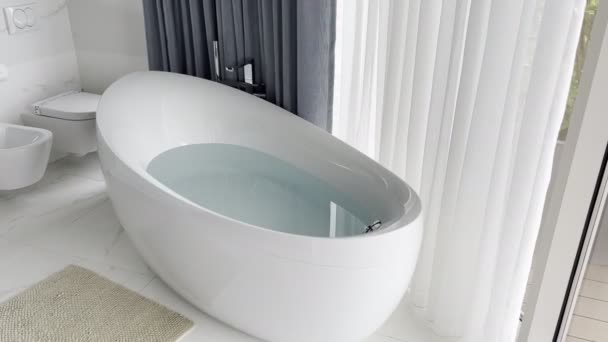 Ovale Badewanne Mit Wasser Badezimmer Neben Dem Fenster Hochwertiges Filmmaterial — Stockvideo