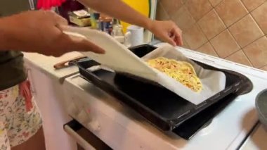 The cook places the pizza on a baking sheet. High quality 4k footage
