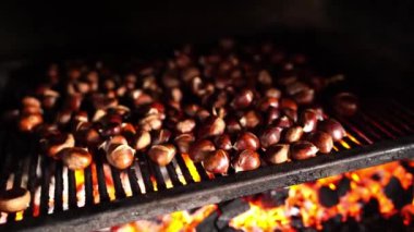 Chestnuts are baking on the coals in the oven. High quality 4k footage