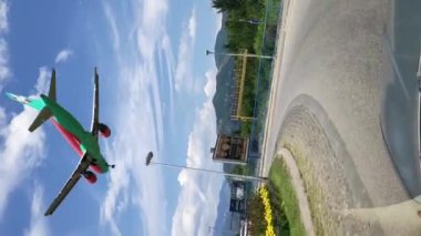 Passenger plane flies low along a busy highway with moving cars. High quality FullHD footage