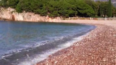Waves roll on the pebble beach near Villa Milocer. Montenegro. High quality FullHD footage