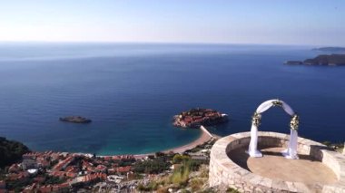 Wedding arch stands on a viewpoint overlooking the Sveti Stefan island. High quality FullHD footage