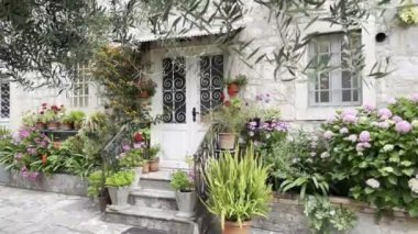 Porch of an old stone house with flowers in pots and a canopy over the entrance. High quality 4k footage