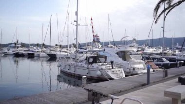 Expensive yachts are moored on the pier against the backdrop of the mountains. High quality FullHD footage