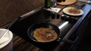 Man removes a pancake with a crispy crust from a frying pan to a plate. High quality 4k footage