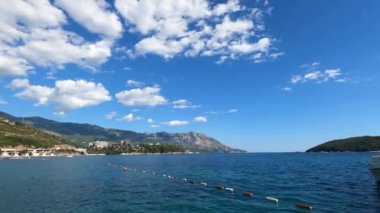 Budva 'nın deniz kıyısında, yeşil dağların eteğinde şamandıralarla ayrılmış. Karadağ. Yüksek kalite 4k görüntü