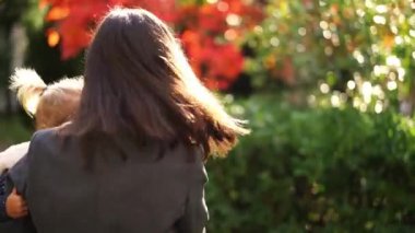 Mom is spinning in the garden with a little girl in her arms. High quality 4k footage