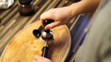 Barmen masandaki portatif filtrede kahveyi kurcalayıcı ile ezer. Yüksek kalite 4k görüntü