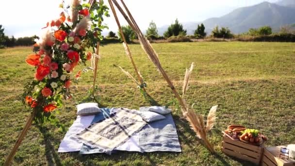 枕が敷き詰められたベッドは インドのウィグワムのスタイルで結婚式のアーチの下の緑の芝生の上にあります 高品質4K映像 — ストック動画