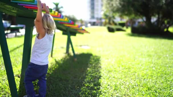 Fetița Leagănă Bancă Multicoloră Din Parc Atârnând Mâini Imagini Înaltă — Videoclip de stoc