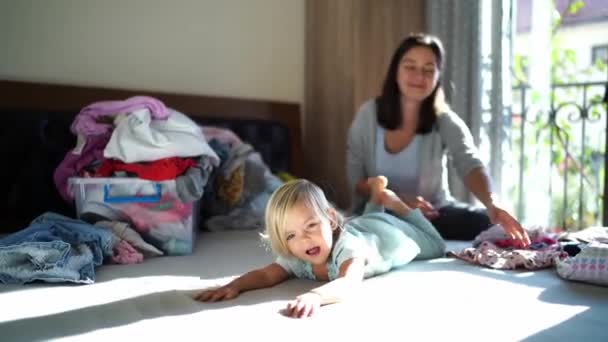 Little Girl Lies Bed Waving Her Legs Next Her Mother — Video Stock