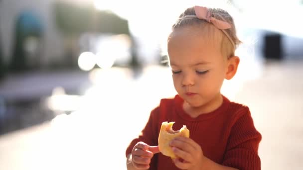 Little Girl Eats Bun Jam Examines Filling Outdoors High Quality — 비디오