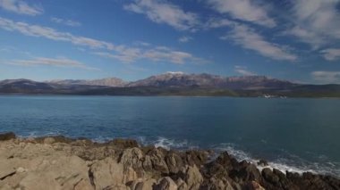 Bulutlu bir gökyüzünün arka planında deniz kıyısında ıssız bir dağ. Yüksek kalite 4k görüntü