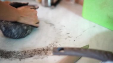 Housewife kneading black dough on the table. High quality 4k footage