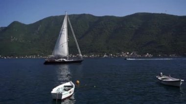 Sailing yacht moored in the sea near fishing boats. High quality FullHD footage